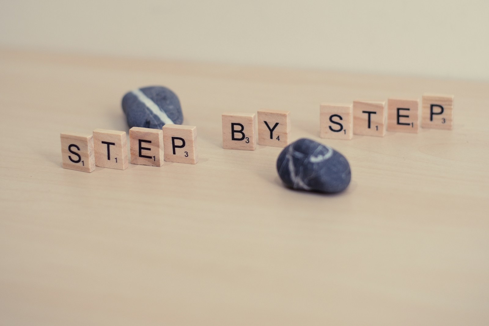 Step by step, wooden letter photography. Wood and stones. Progress